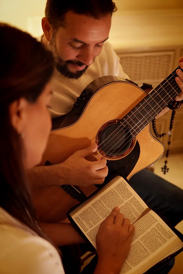 Hugo toca la guitarra mientras Caro lee la Biblia
